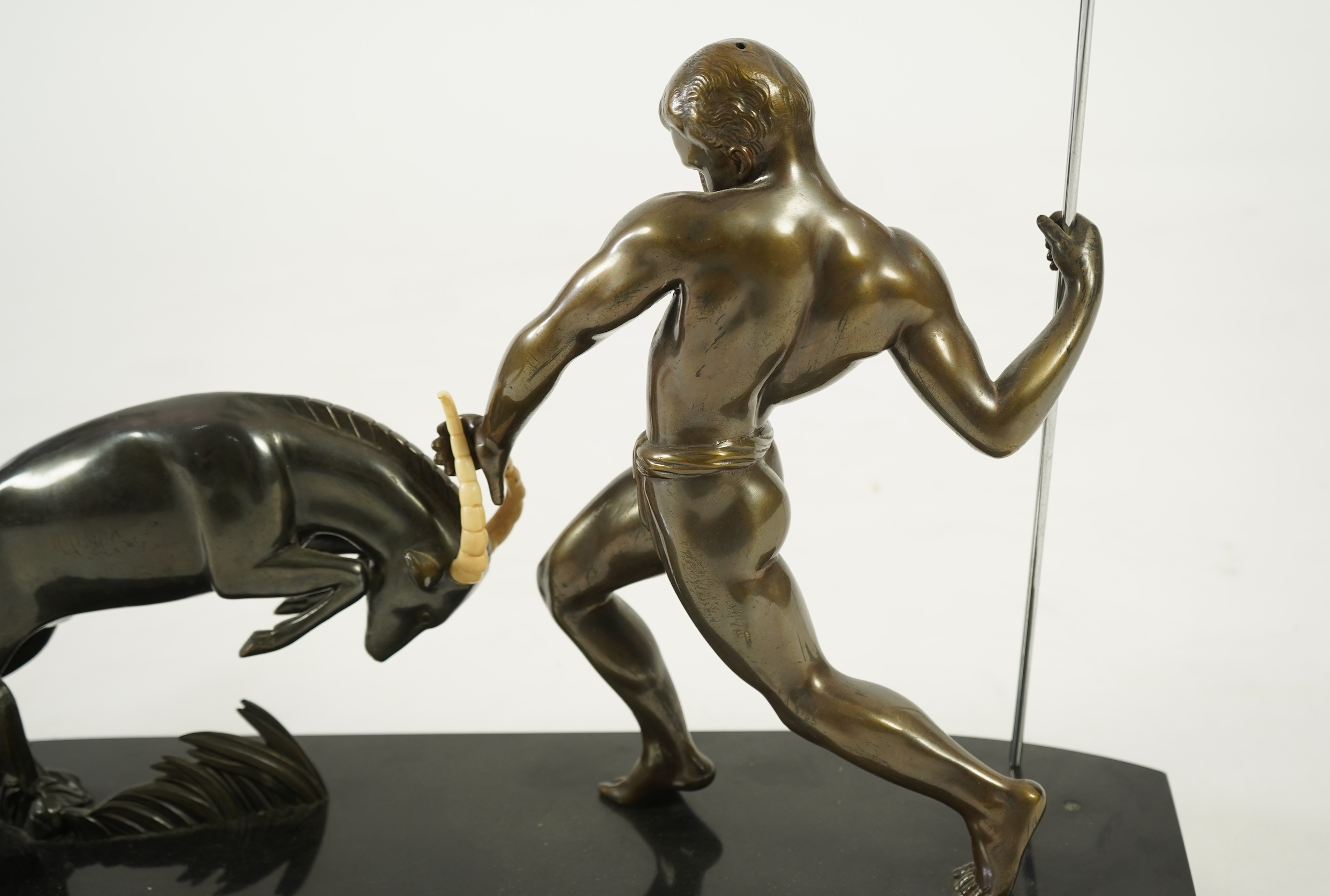 Attributed to Zoltan Kovasz (Romanian, 1883-1952), a bronzed spelter male hunter holding a chromed spear, with springbok, on a polished slate base
